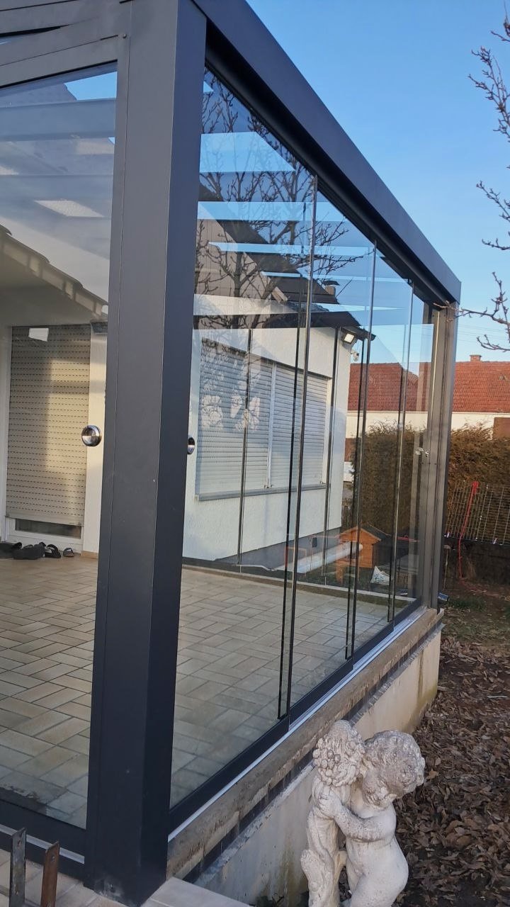 Glasschiebewand aus ESG-Glas an der Ecke einer Alu-Terrassenüberdachung