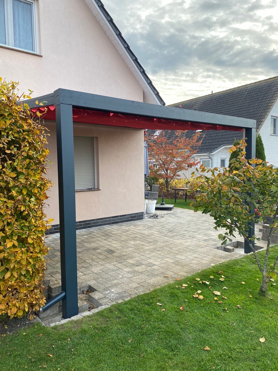 Freistehende Alu-Terrassenüberdachung mit Seilspannmarkise in Weinrot