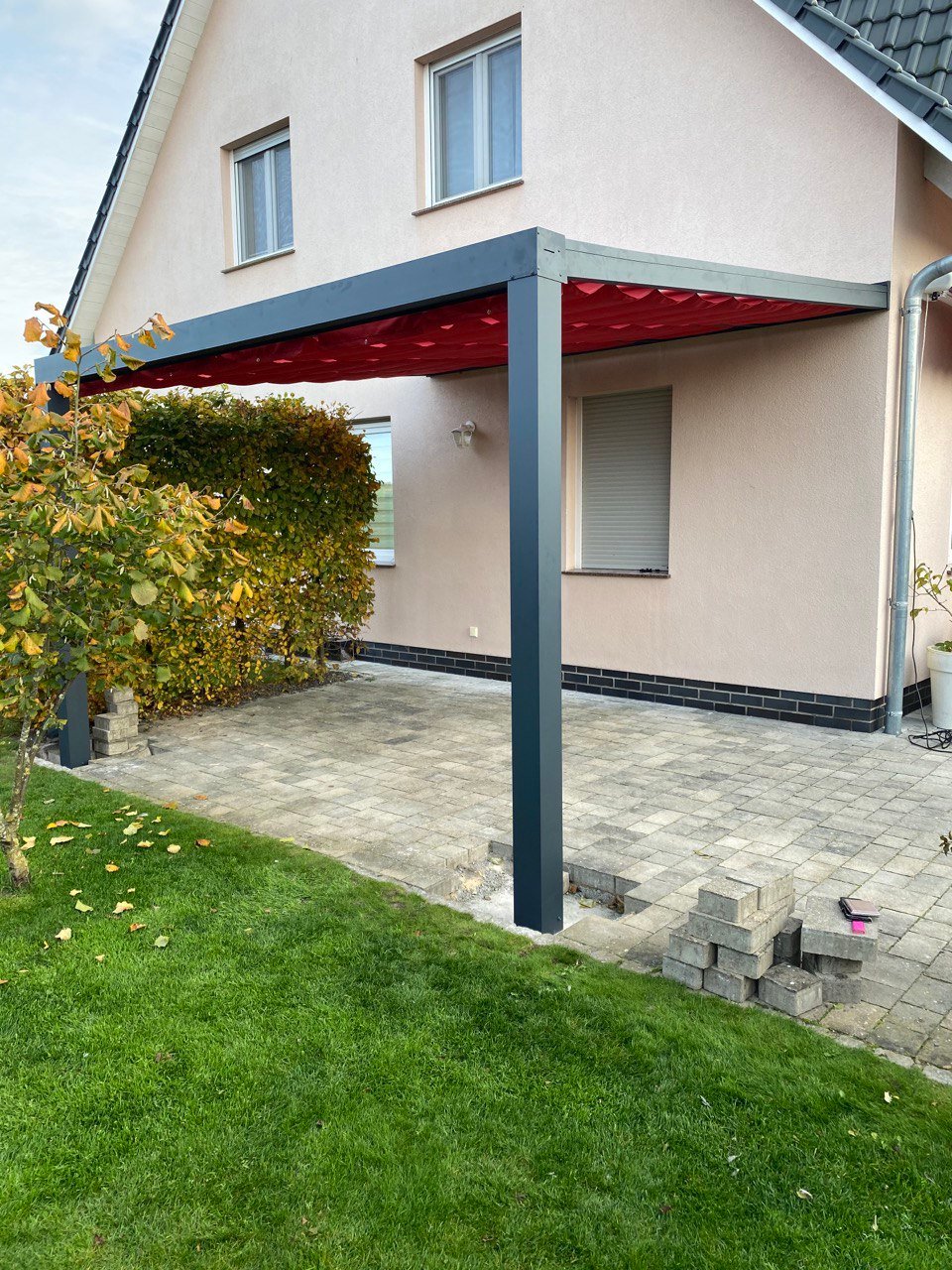 Alu-Pfosten einer Terrassenüberdachung auf einbetoniertem Fundament im Pflaster
