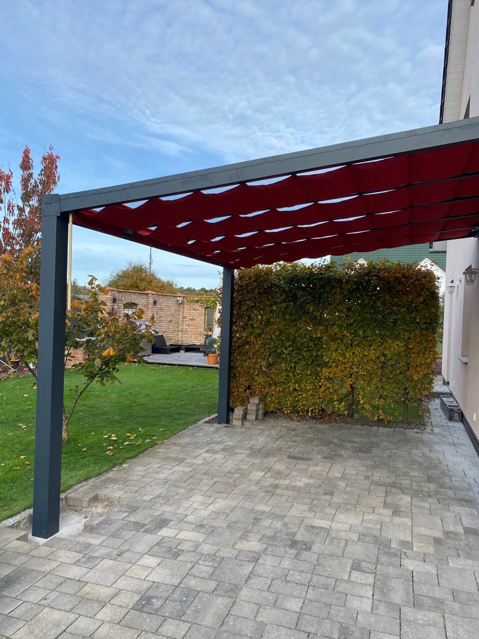 Seilspannmarkise in Weinrot unter einer Alu-Terrassenüberdachung